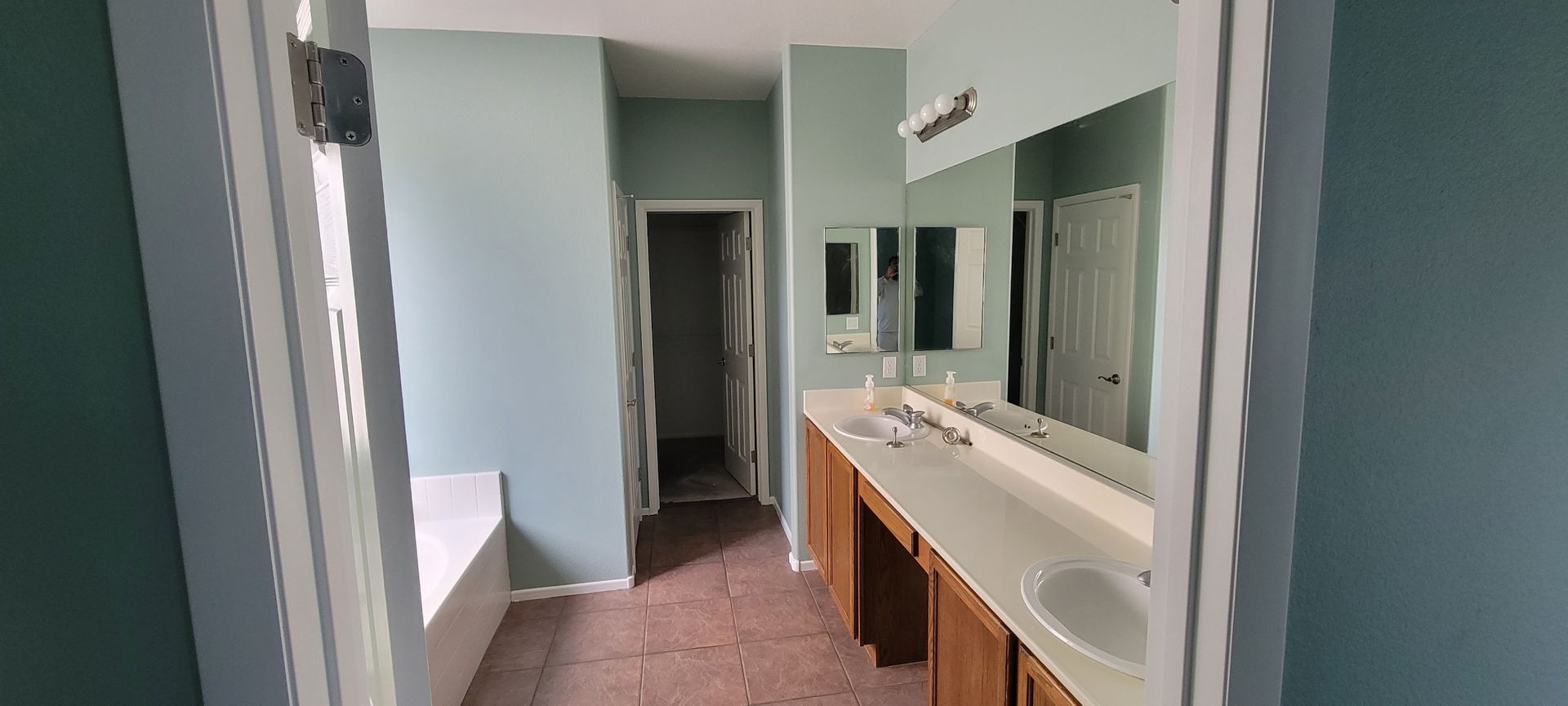 A bathroom with two sinks and a large mirror.