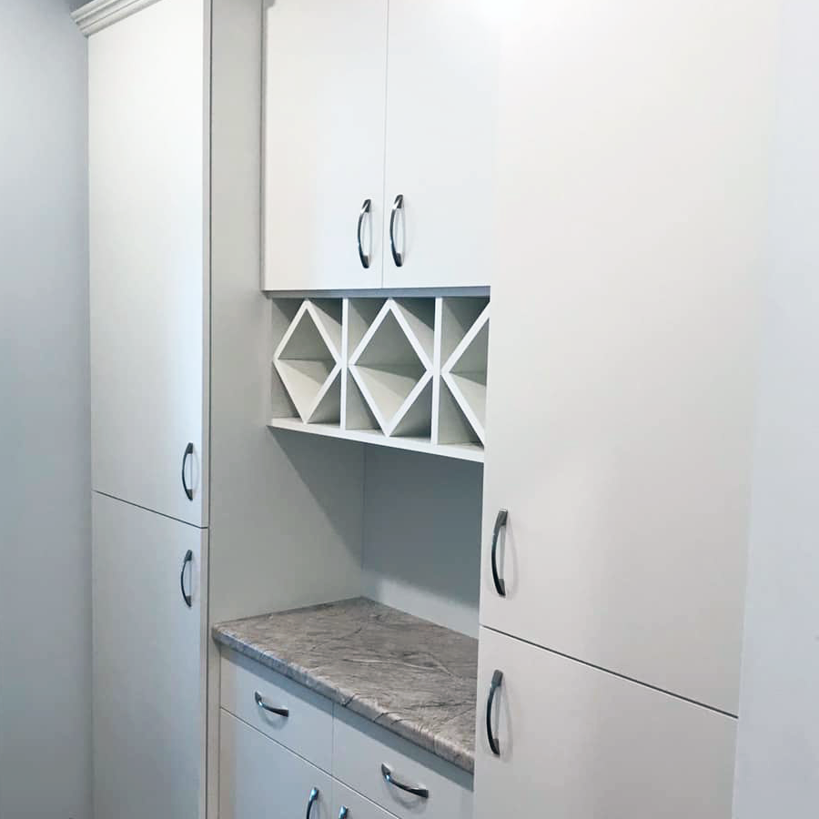 White built-in cabinetry with a wine rack and granite countertop.