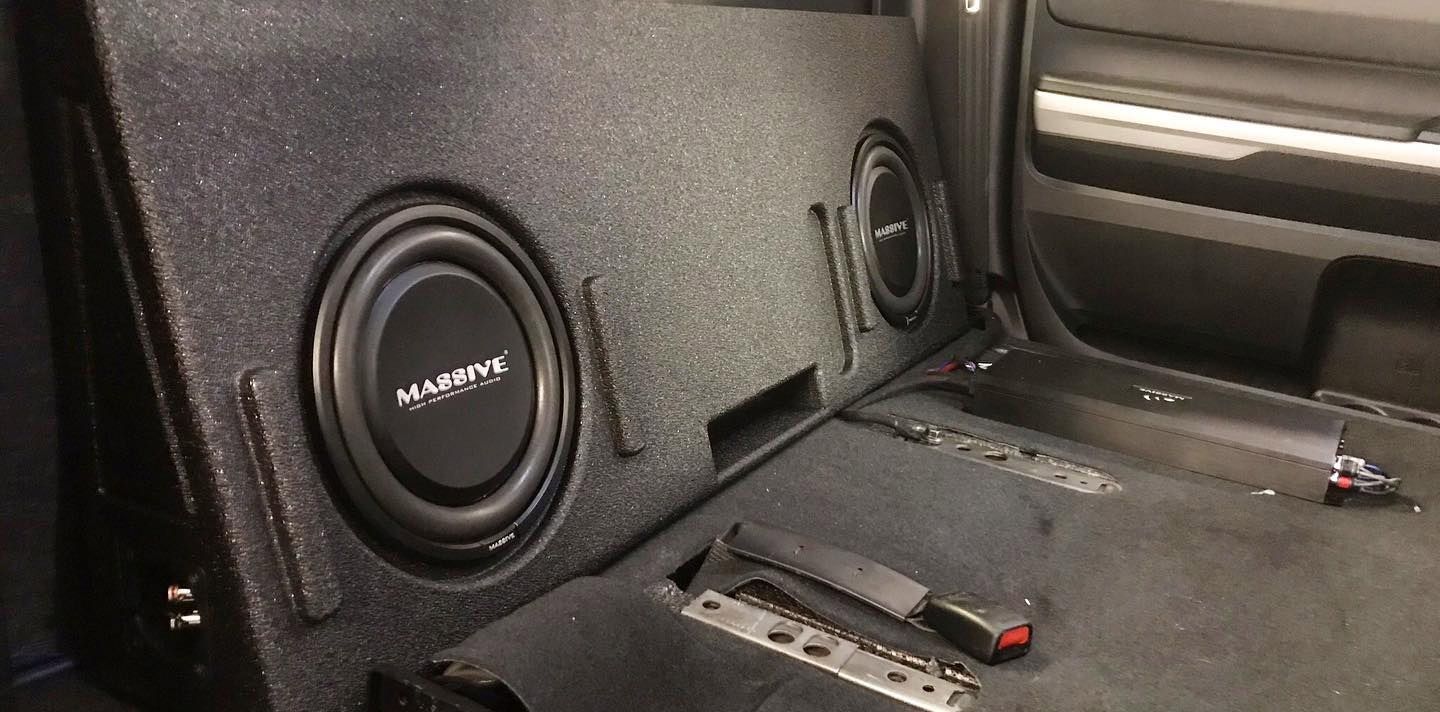 Black truck interior with subwoofer speakers installed in the back.