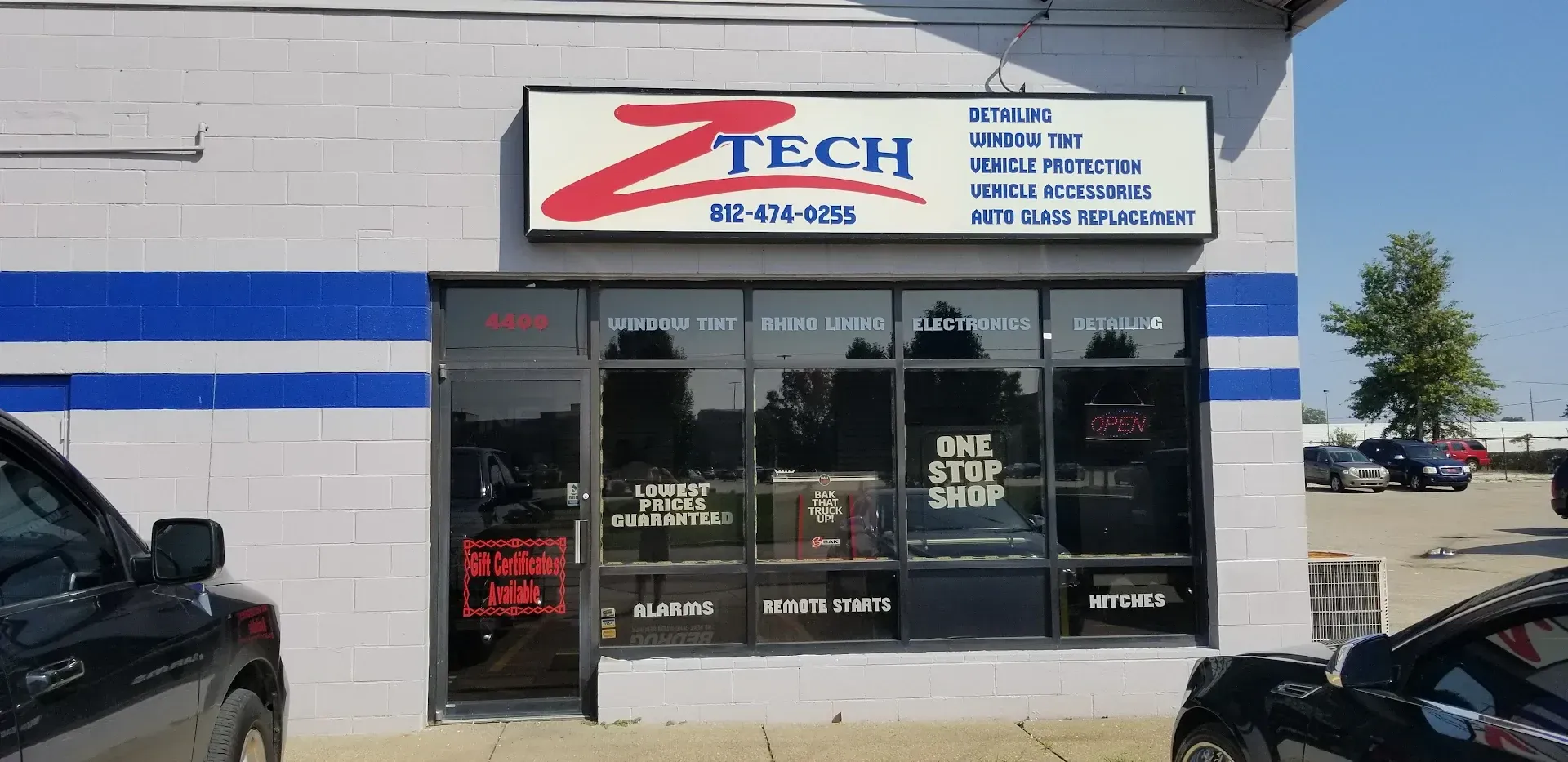 Exterior of Z-Tech auto shop. Signage includes logo, services, and phone number. Storefront has windows and a door.