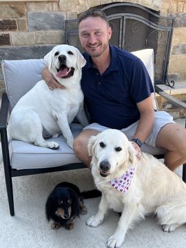 A man sitting on a couch with two dogs