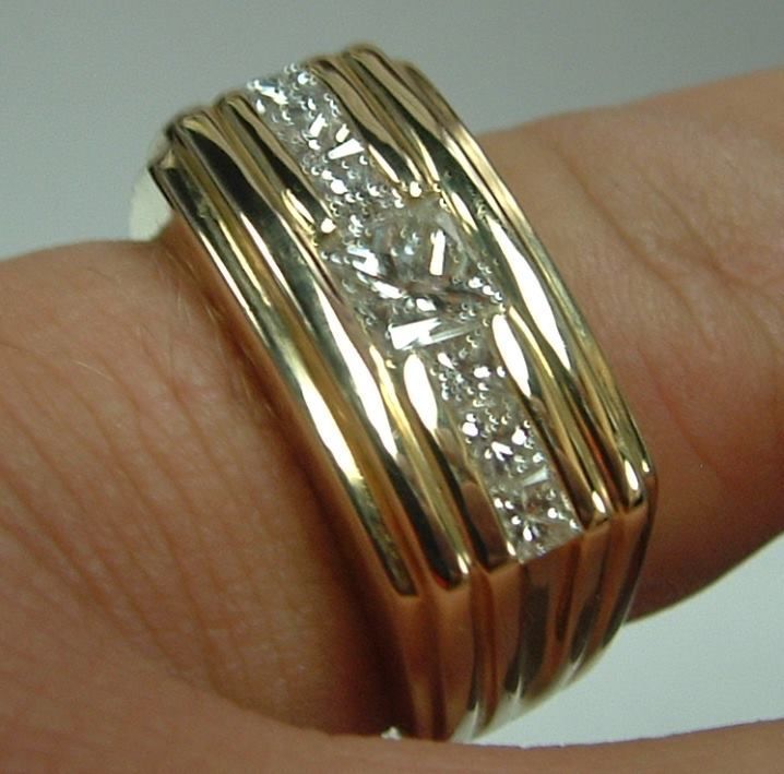 Gold ring with channel-set diamonds on a finger. The ring has ridged sides.