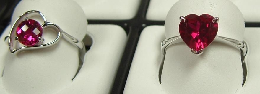 Two rings with heart-shaped gemstones. One has a heart-shaped setting, the other a heart-shaped gem.