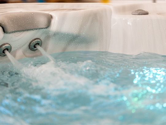 A close up of a hot tub filled with blue water.