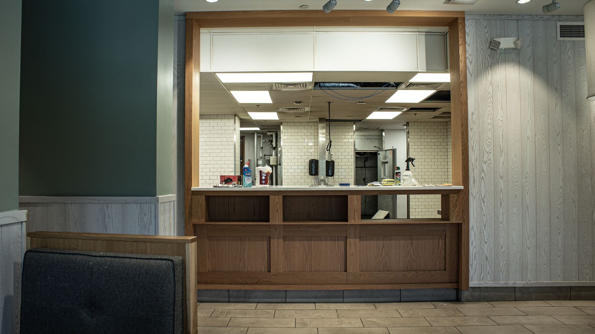 Empty service window with wooden counter in a softly lit indoor hallway