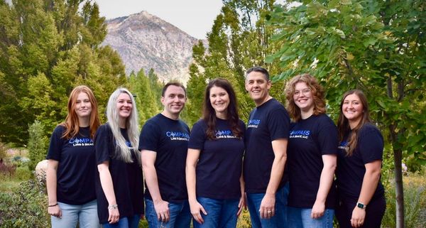 A group of people are posing for a picture in front of a mountain.