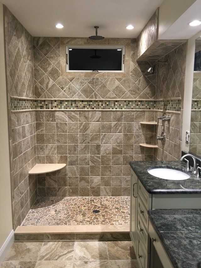 A bathroom with a walk in shower and a sink.