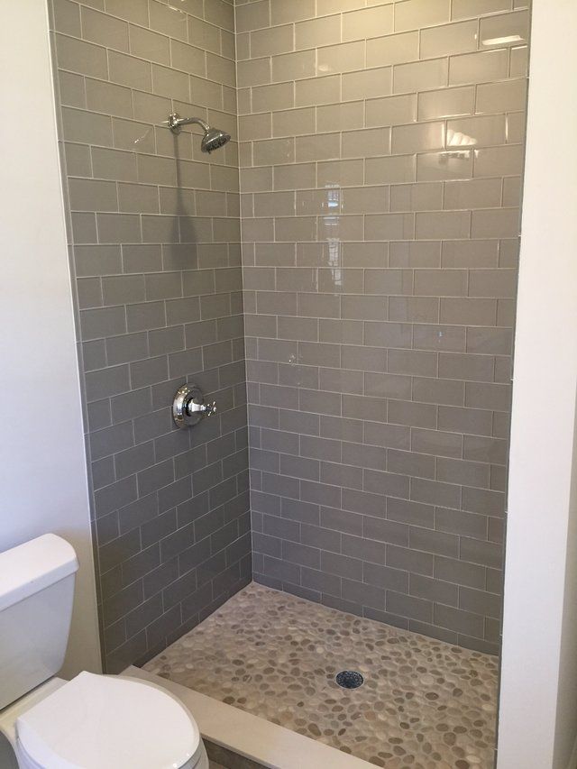 A bathroom with a toilet and a walk in shower.