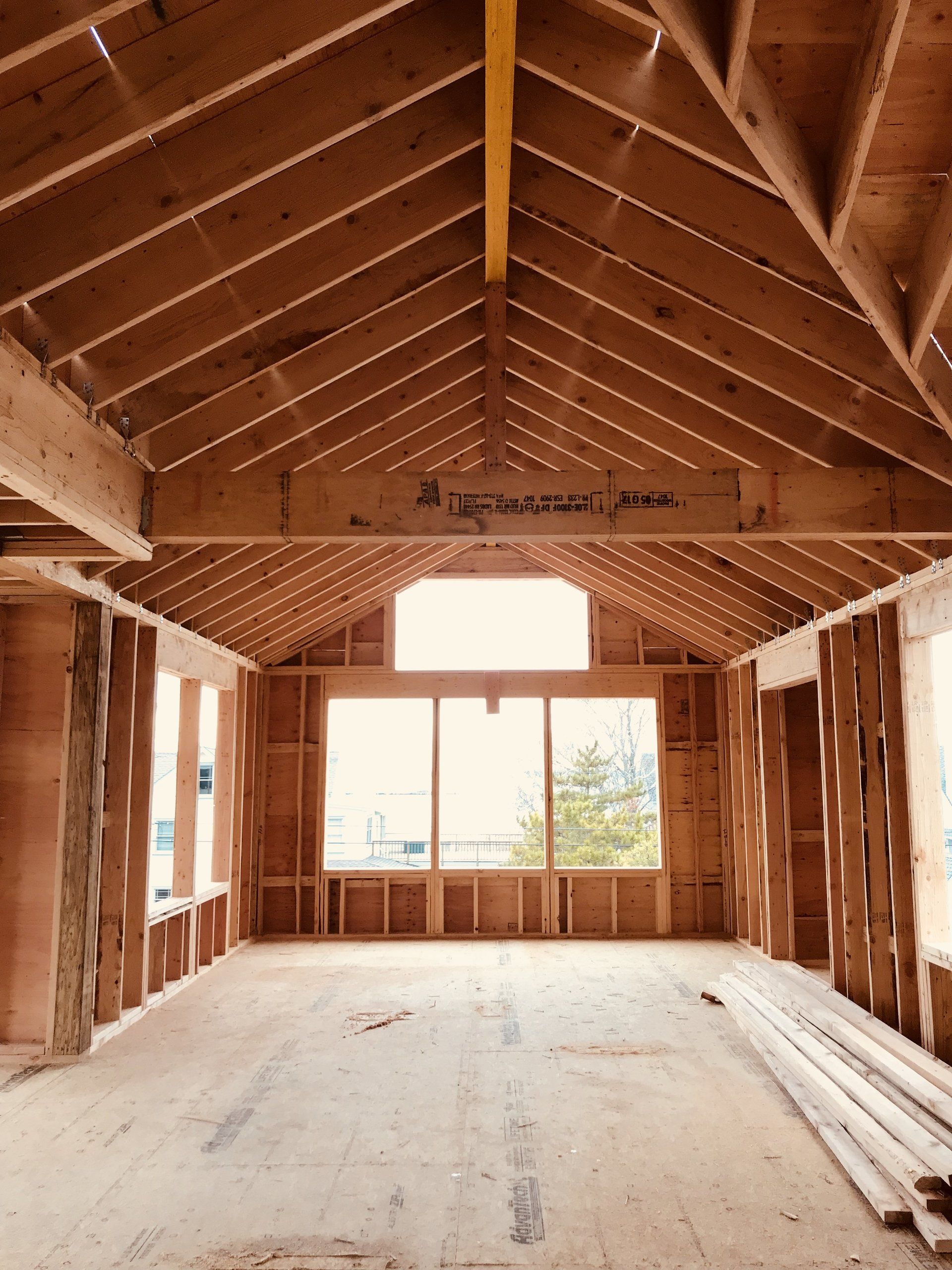 An empty room with a wooden ceiling and lots of windows