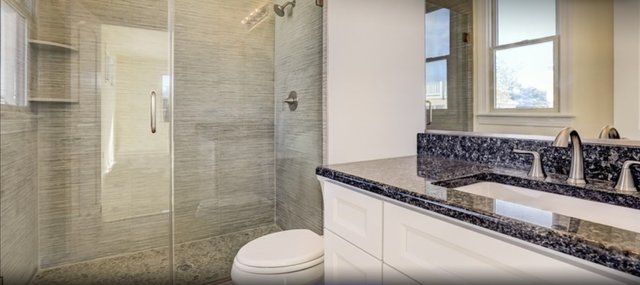 A bathroom with a toilet , sink , and walk in shower.