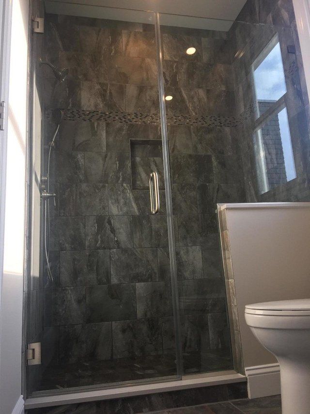 A bathroom with a walk in shower and a toilet.