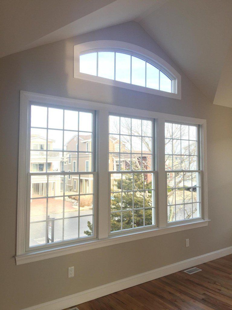 A living room with a lot of windows and a vaulted ceiling.