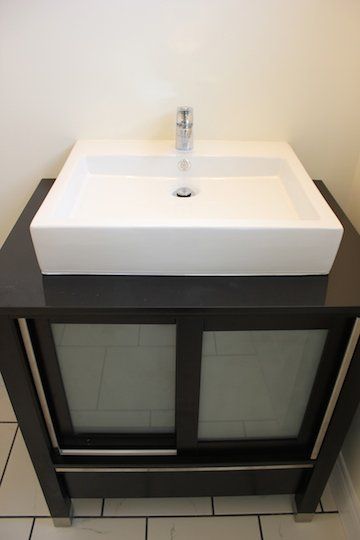 A bathroom sink with a black cabinet underneath it