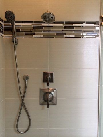 A shower with a shower head and a hose attached to it.