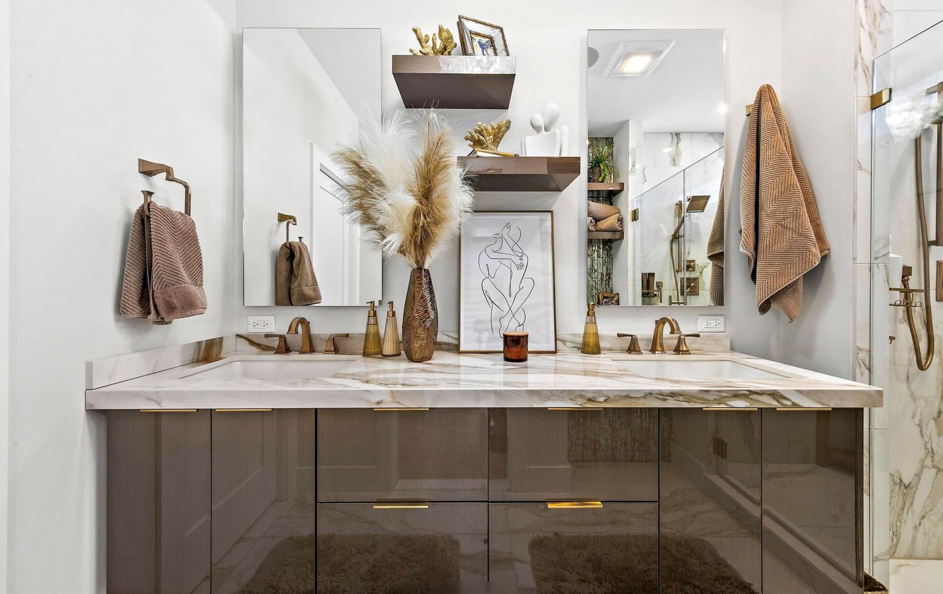A bathroom with two sinks , two mirrors , and a walk in shower.