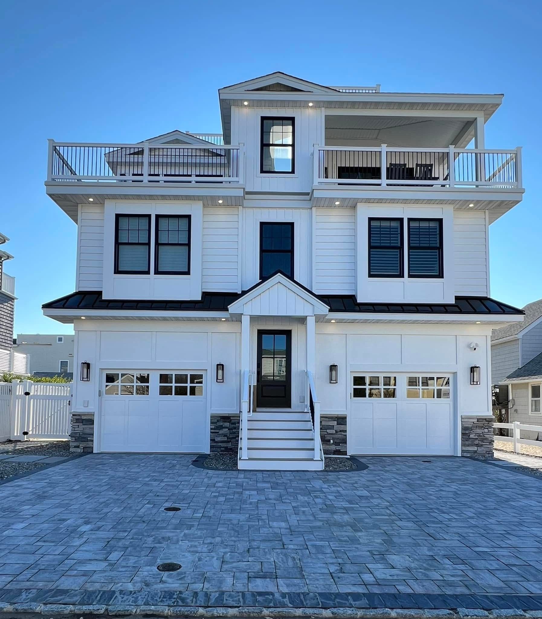 A large white house with a black door and stairs