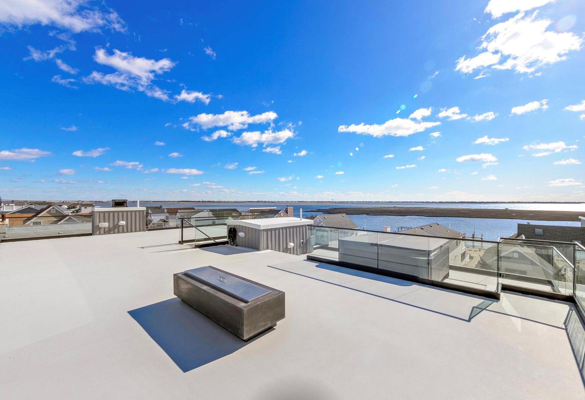 A rooftop deck with a view of a body of water.