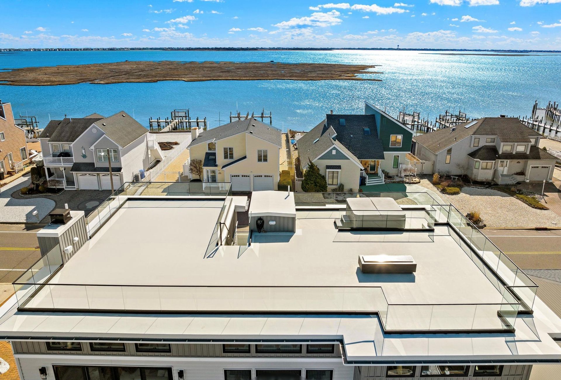 An aerial view of a house with a roof overlooking the ocean.