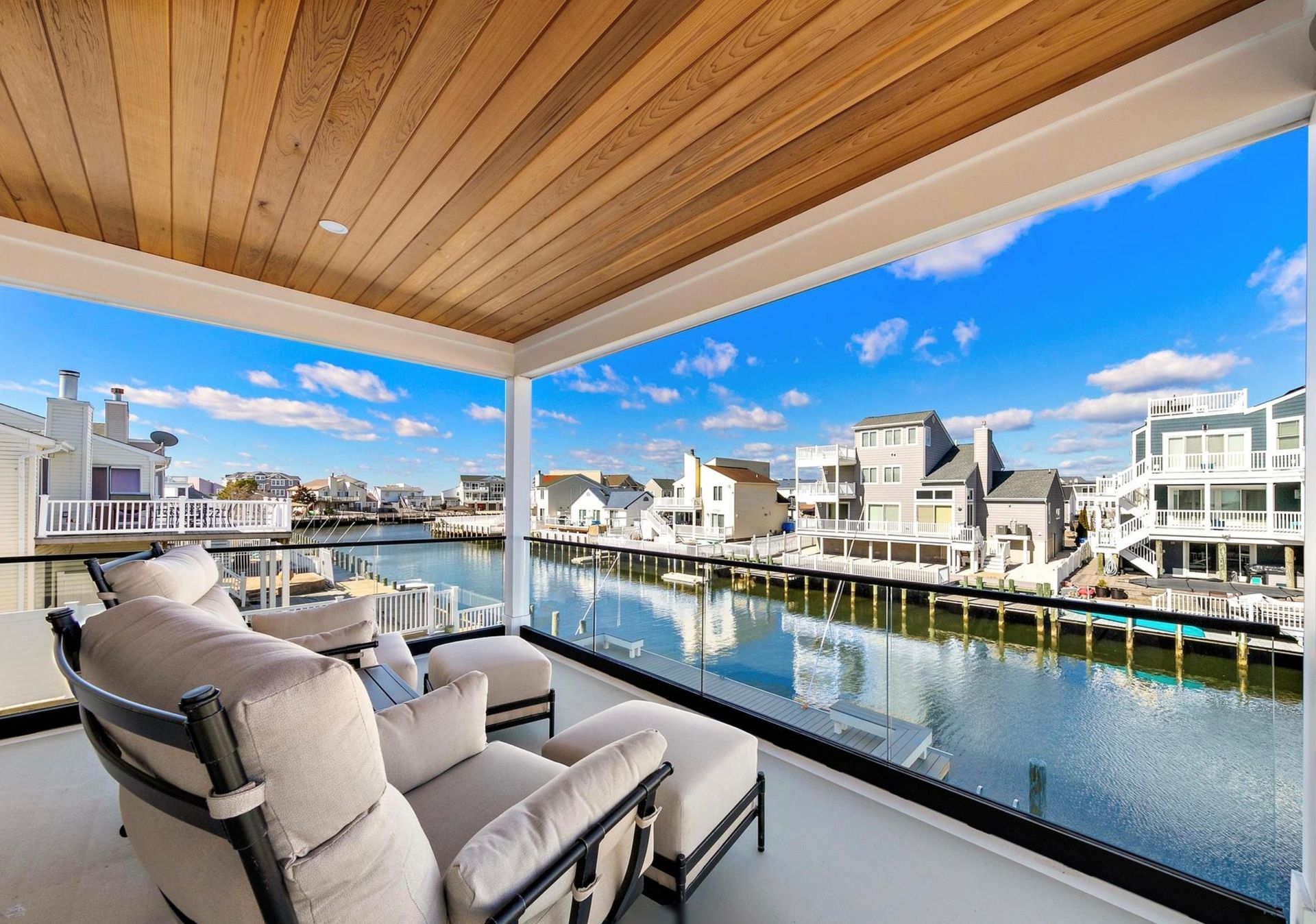 A balcony with chairs and a view of a body of water.