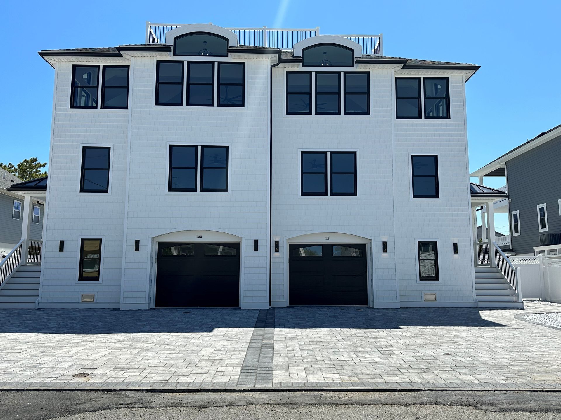 A white building with black windows and black garage doors