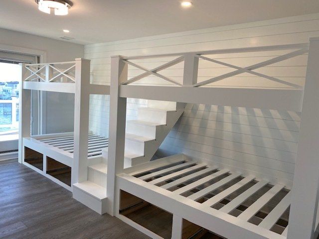 A bedroom with two bunk beds and stairs