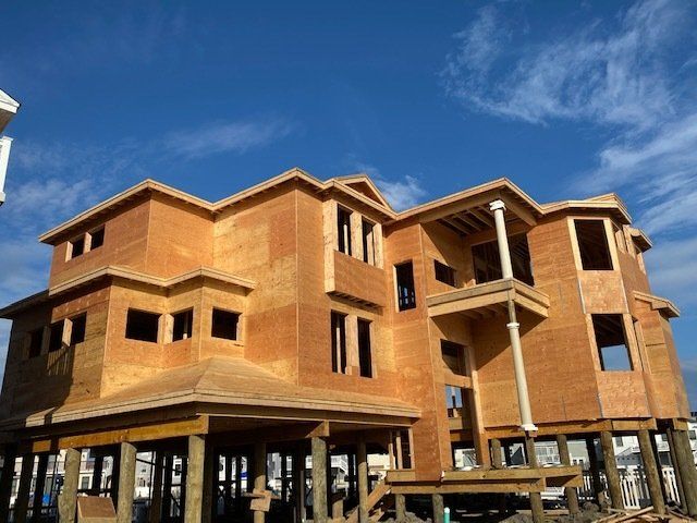 A large house under construction with a blue sky in the background