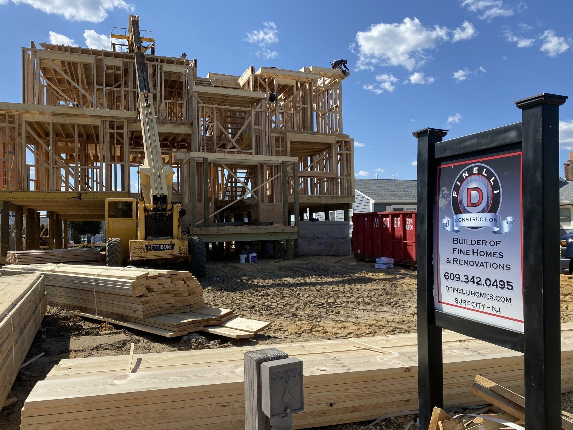 A house is being built with a sign in front of it.