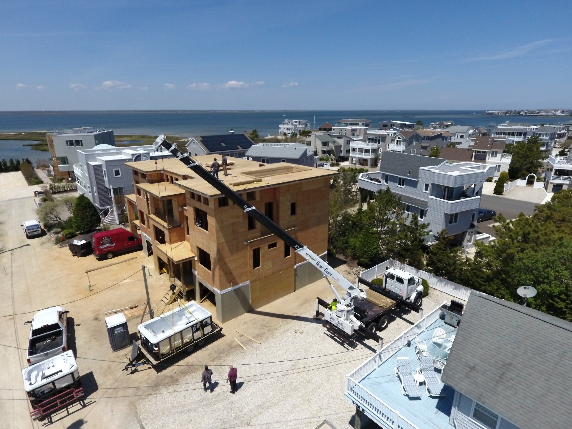An aerial view of a building under construction with a crane in the foreground.