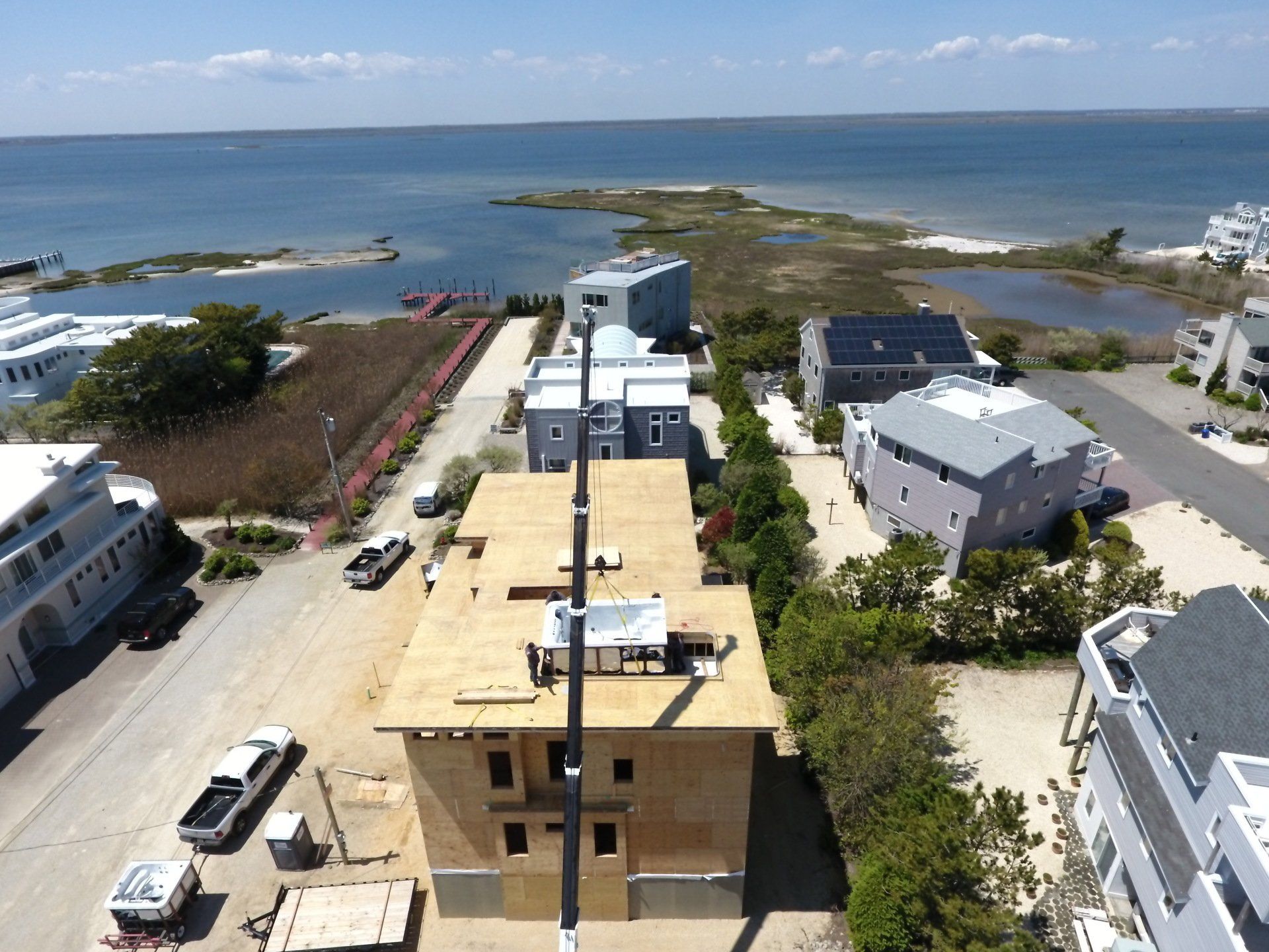 An aerial view of a building under construction with the ocean in the background