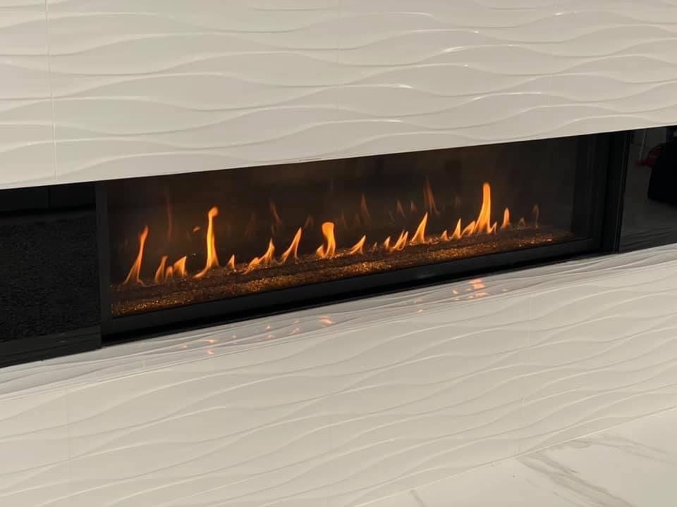 A fireplace with flames coming out of it in a living room.