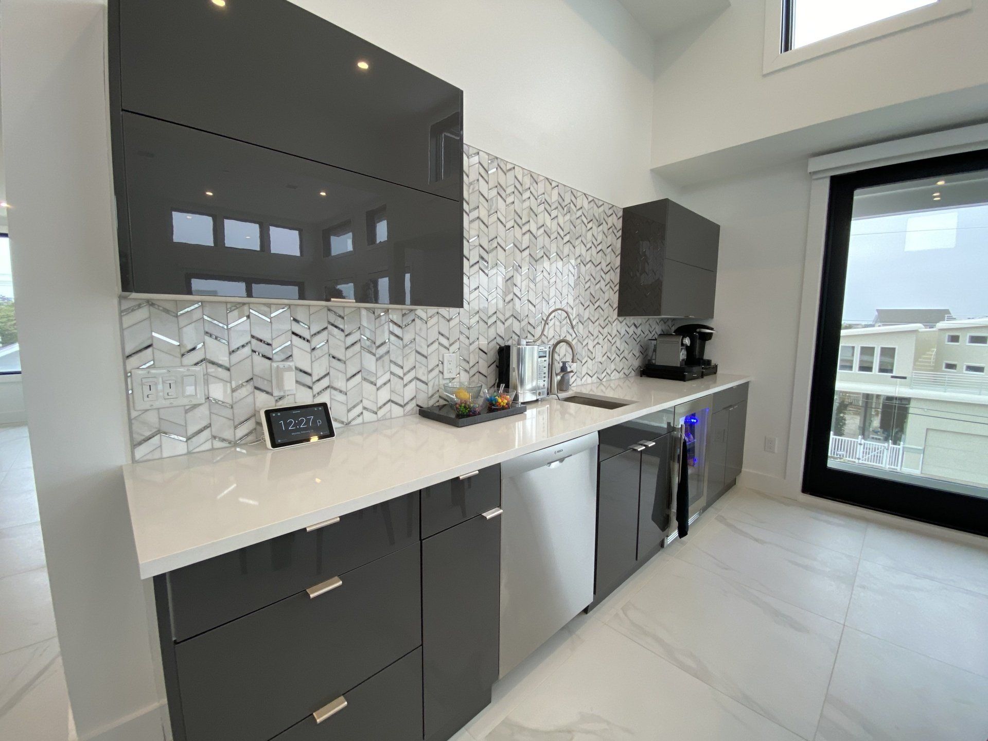 A kitchen with gray cabinets and white counter tops