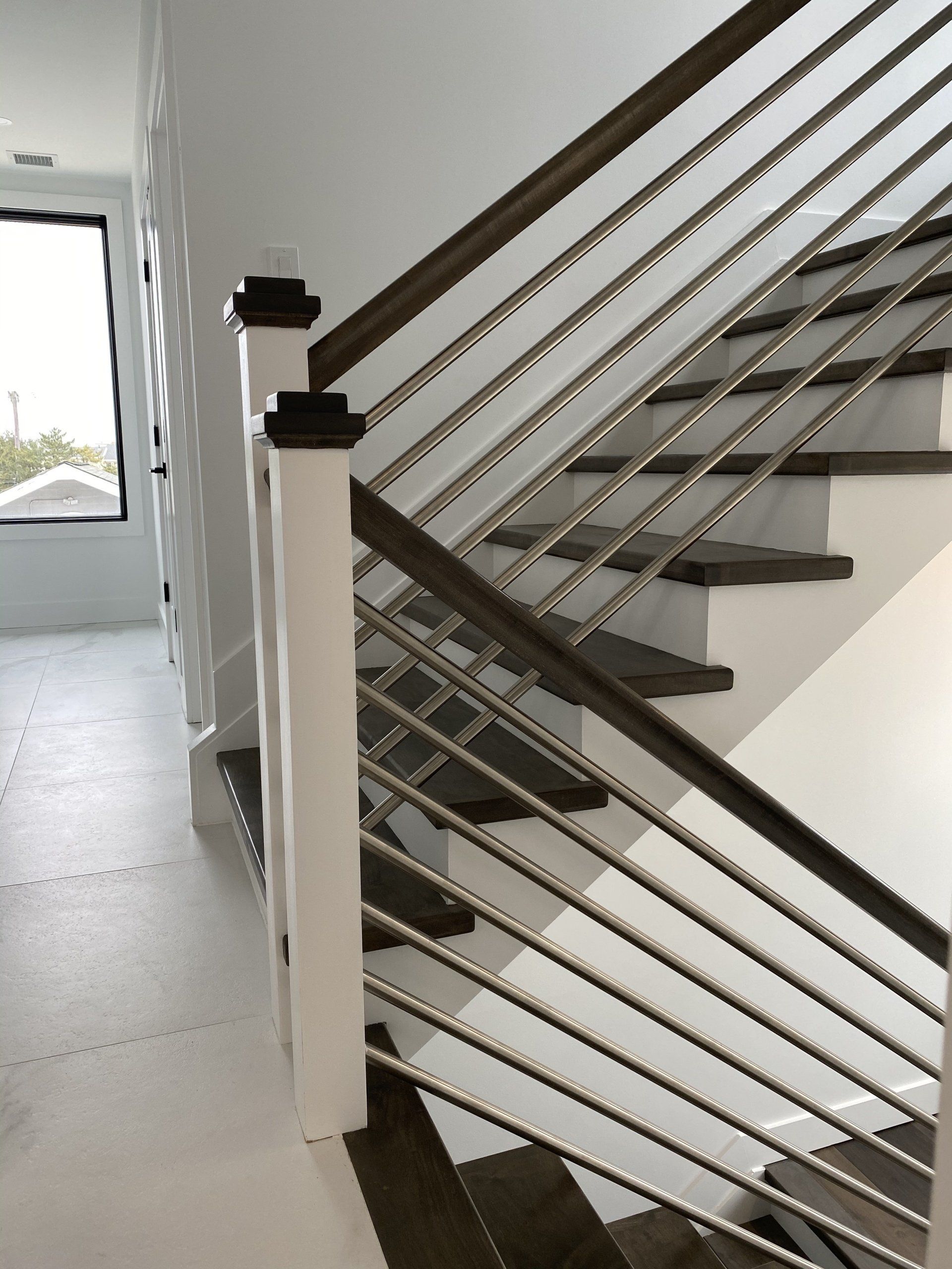 A staircase with a stainless steel railing and wooden steps