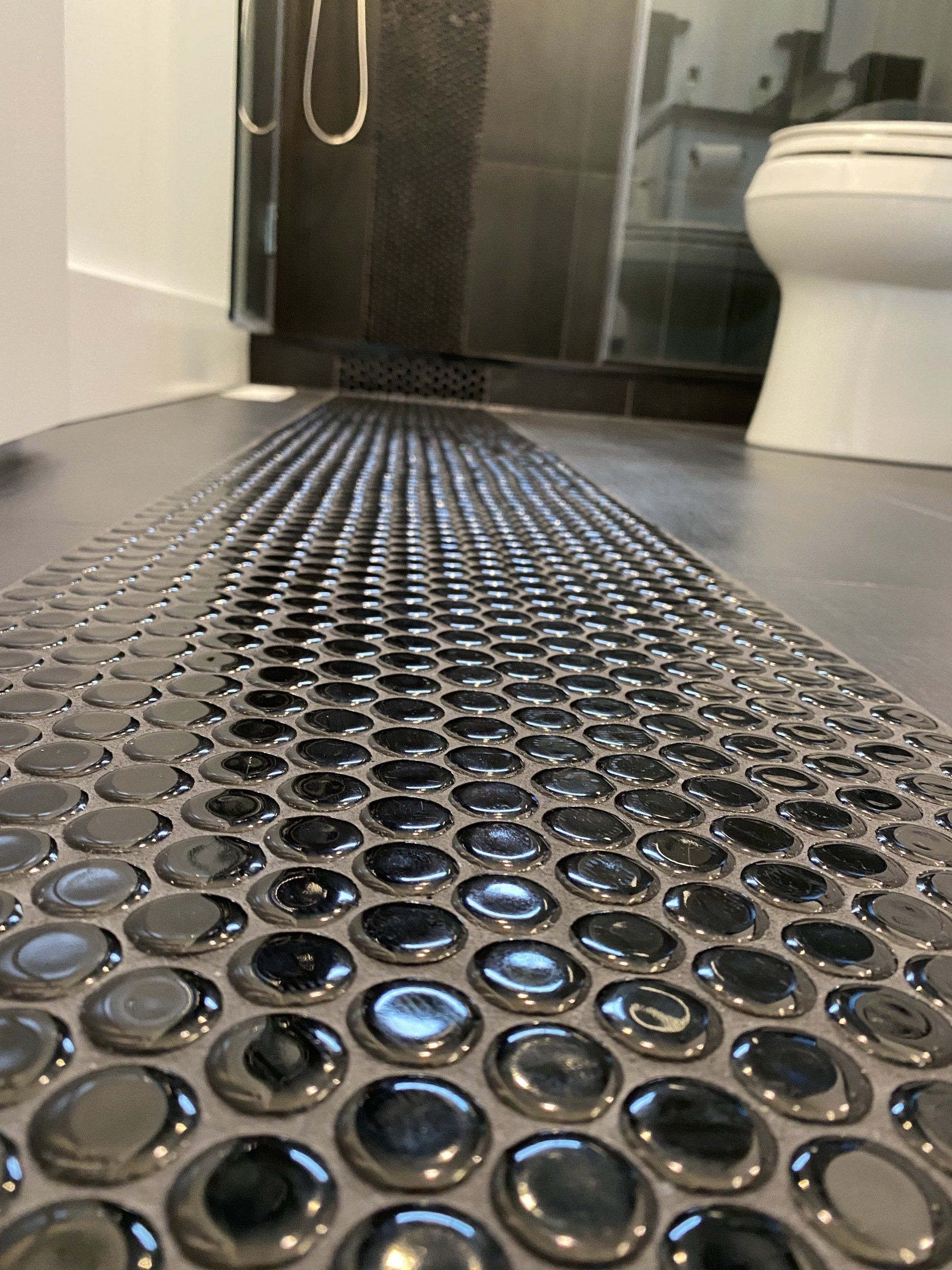 A bathroom with a toilet and a black tile floor