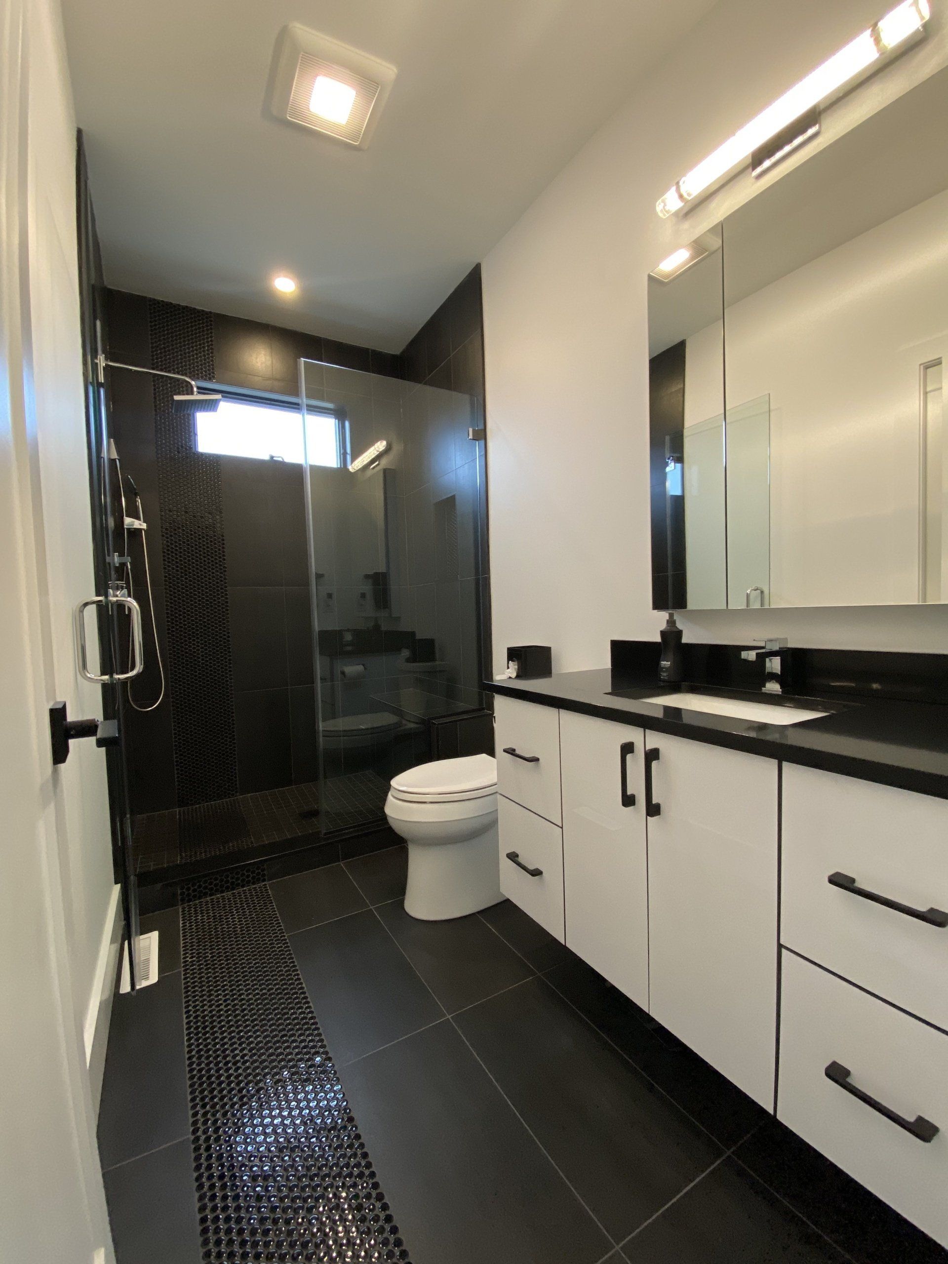 A bathroom with a toilet a sink and a mirror