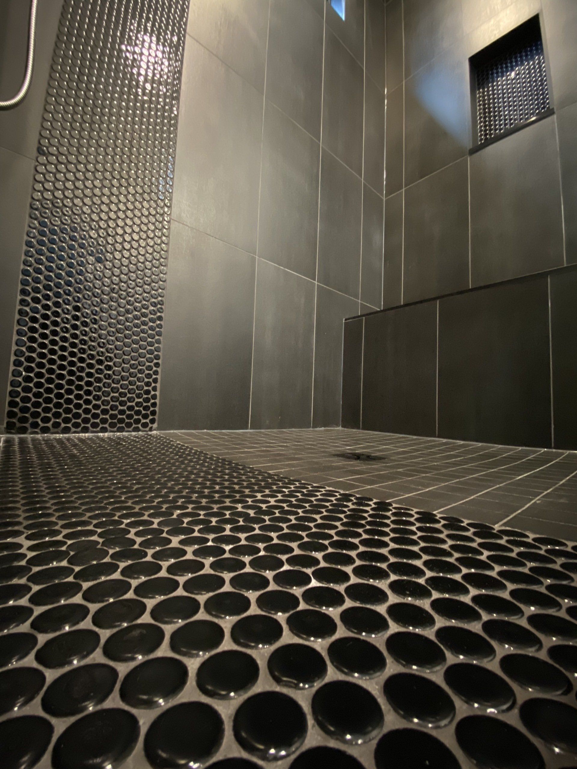 A bathroom with a black tiled floor and a window