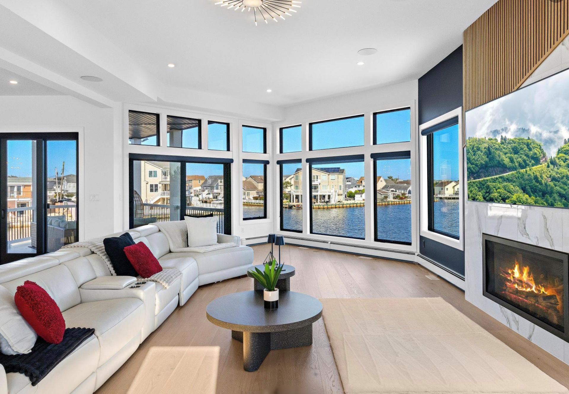A living room filled with furniture and a fireplace with a view of the water.
