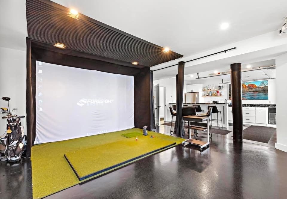 There is a golf simulator in the middle of the room.