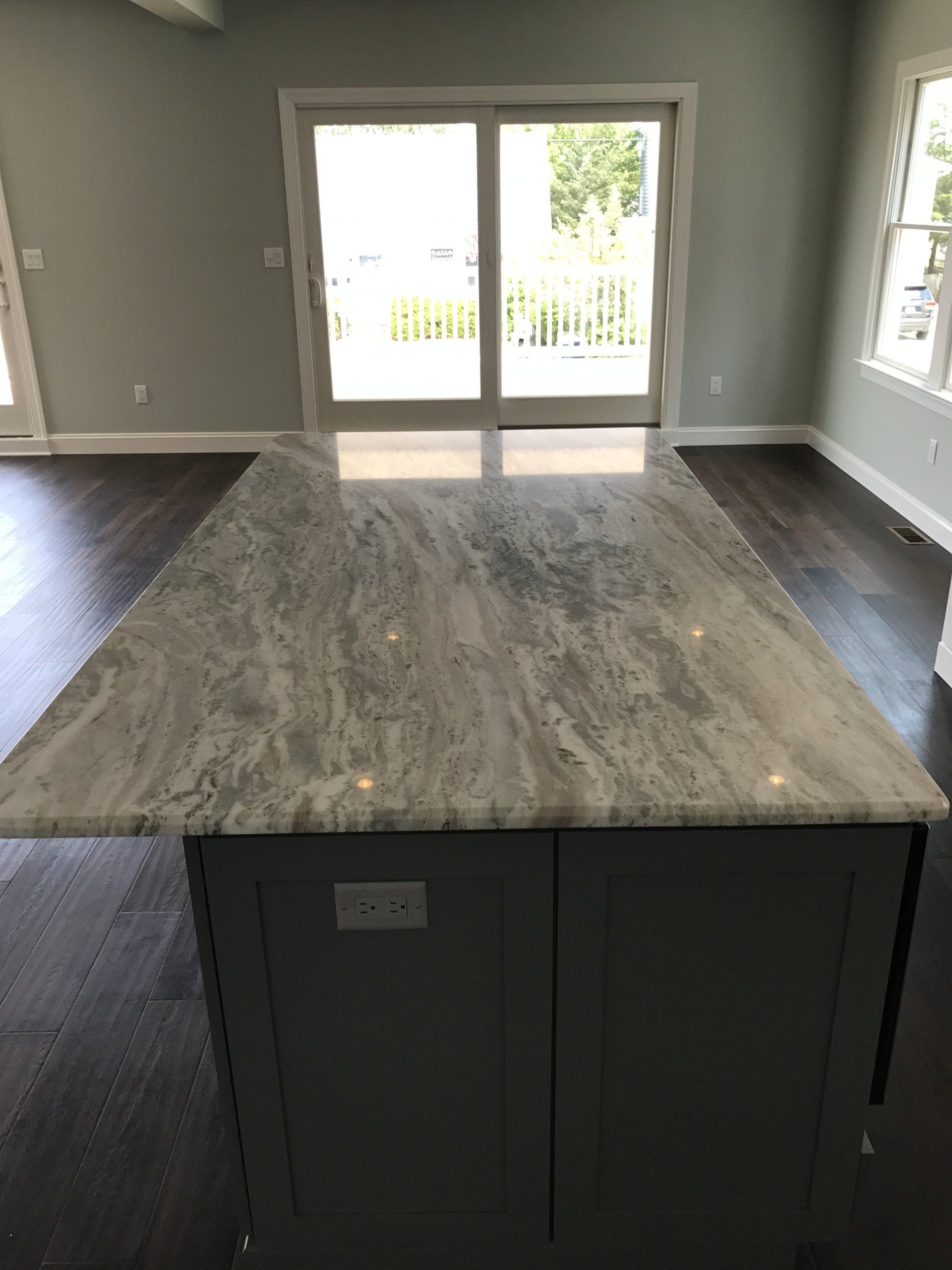 A kitchen with a large granite counter top and sliding glass doors.