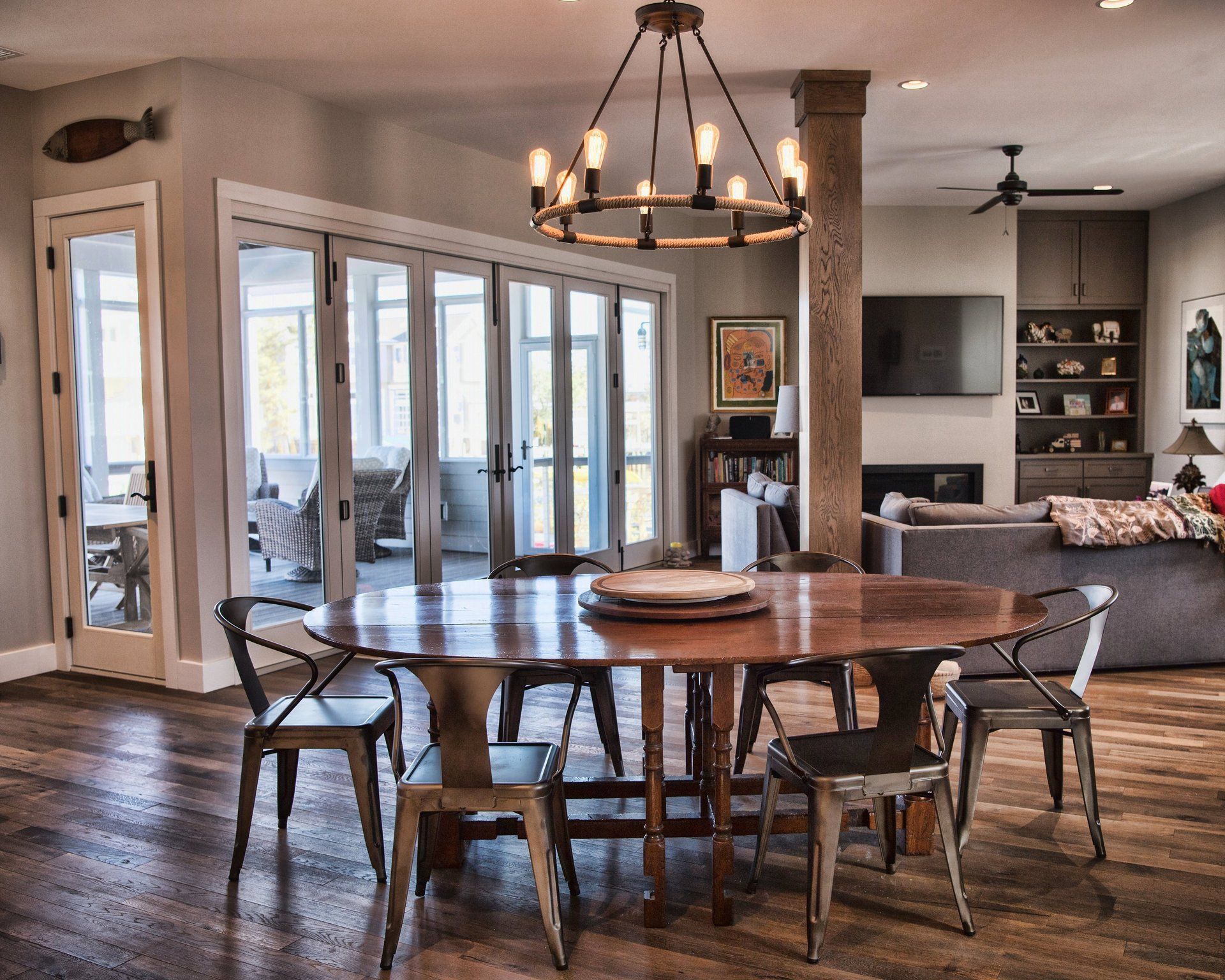 A dining room with a round table and chairs and a chandelier