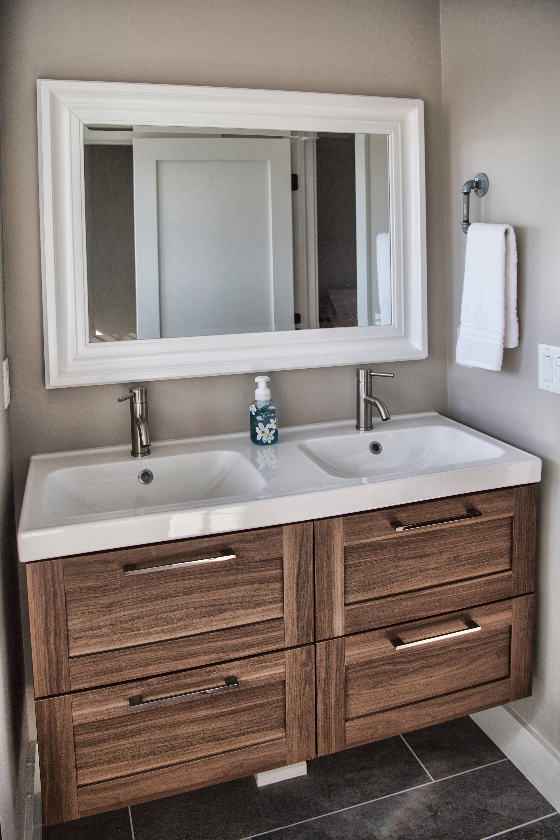 A bathroom with two sinks and a large mirror.