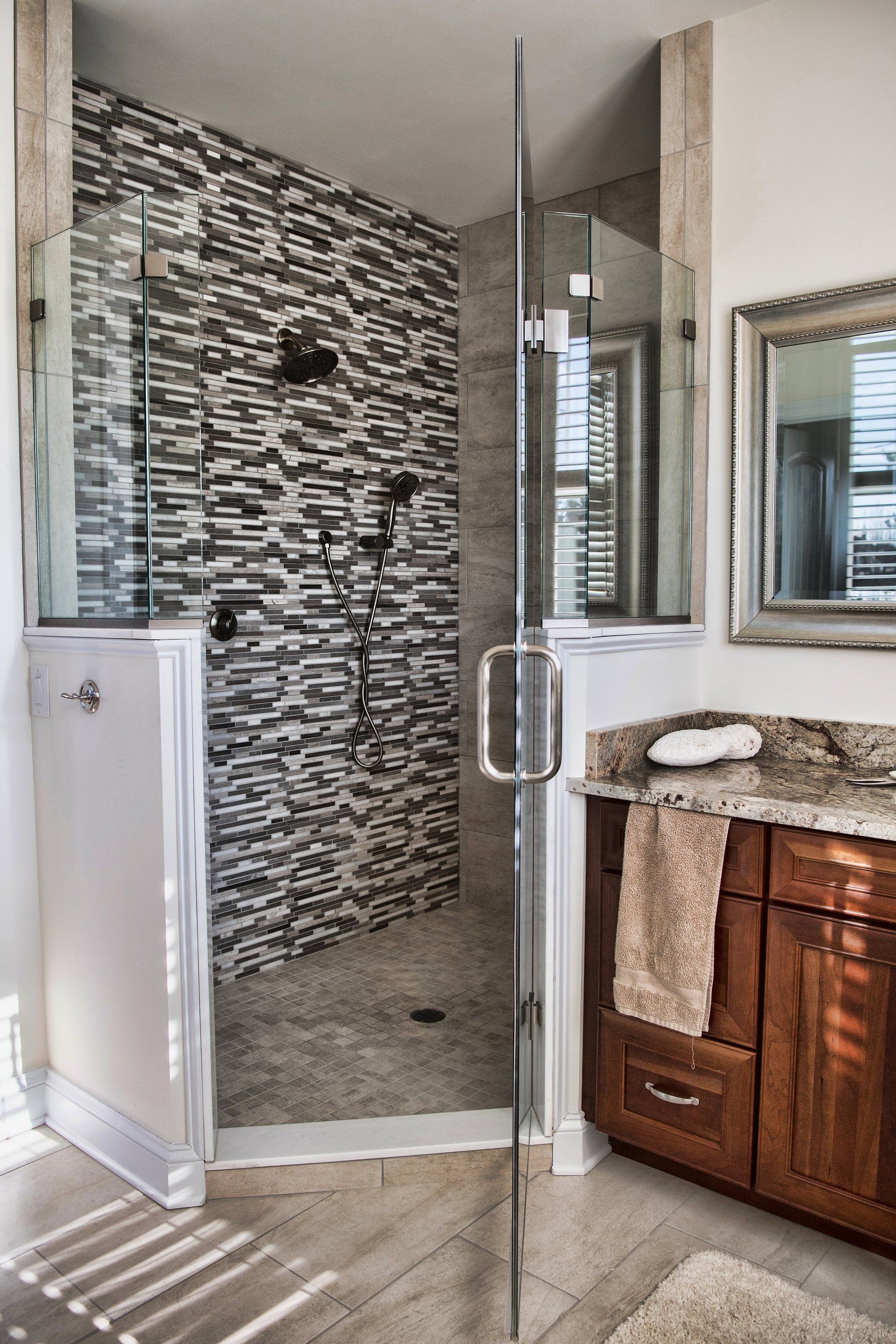 A bathroom with a walk in shower and a mirror.