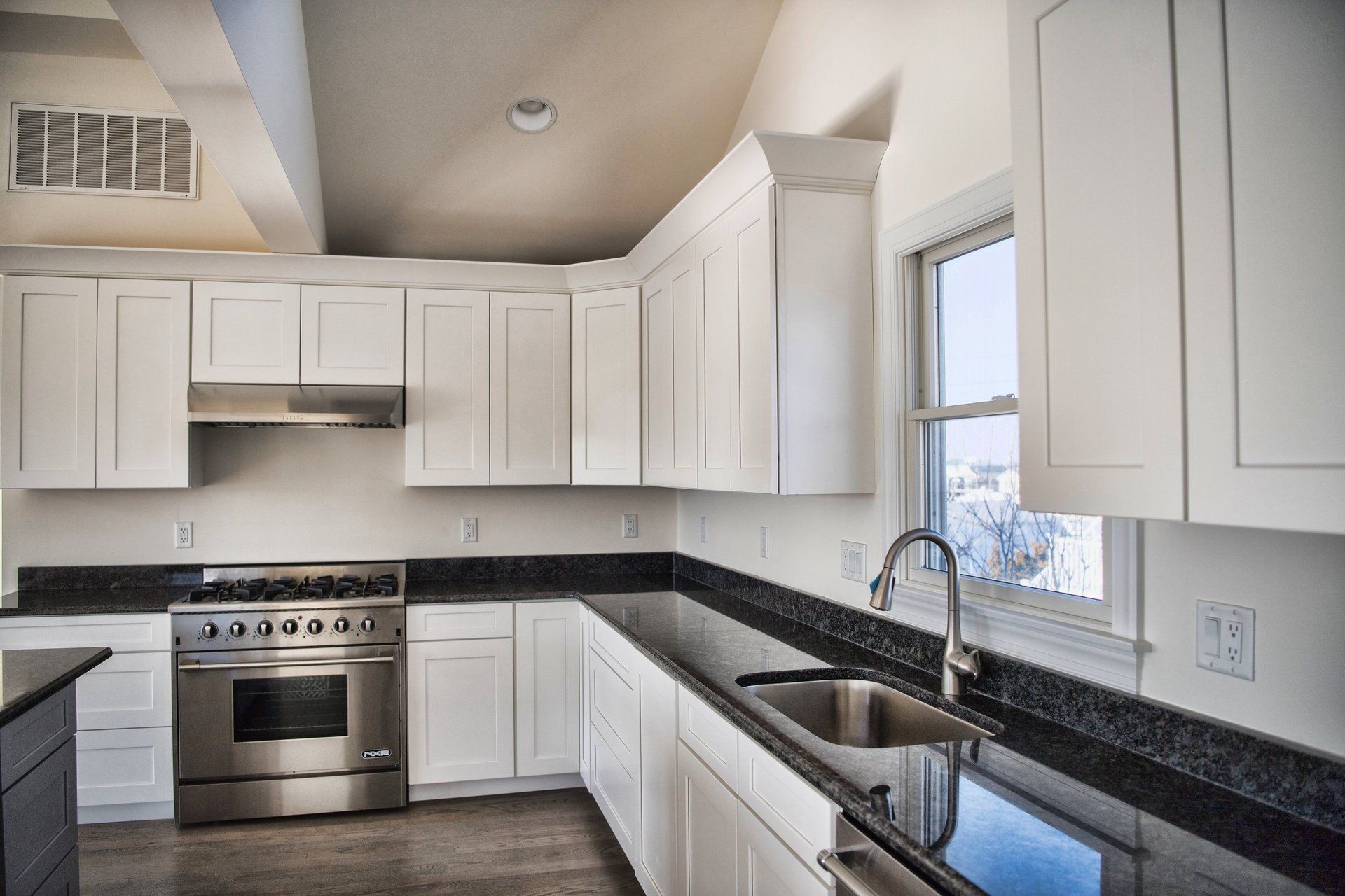 A kitchen with white cabinets and stainless steel appliances