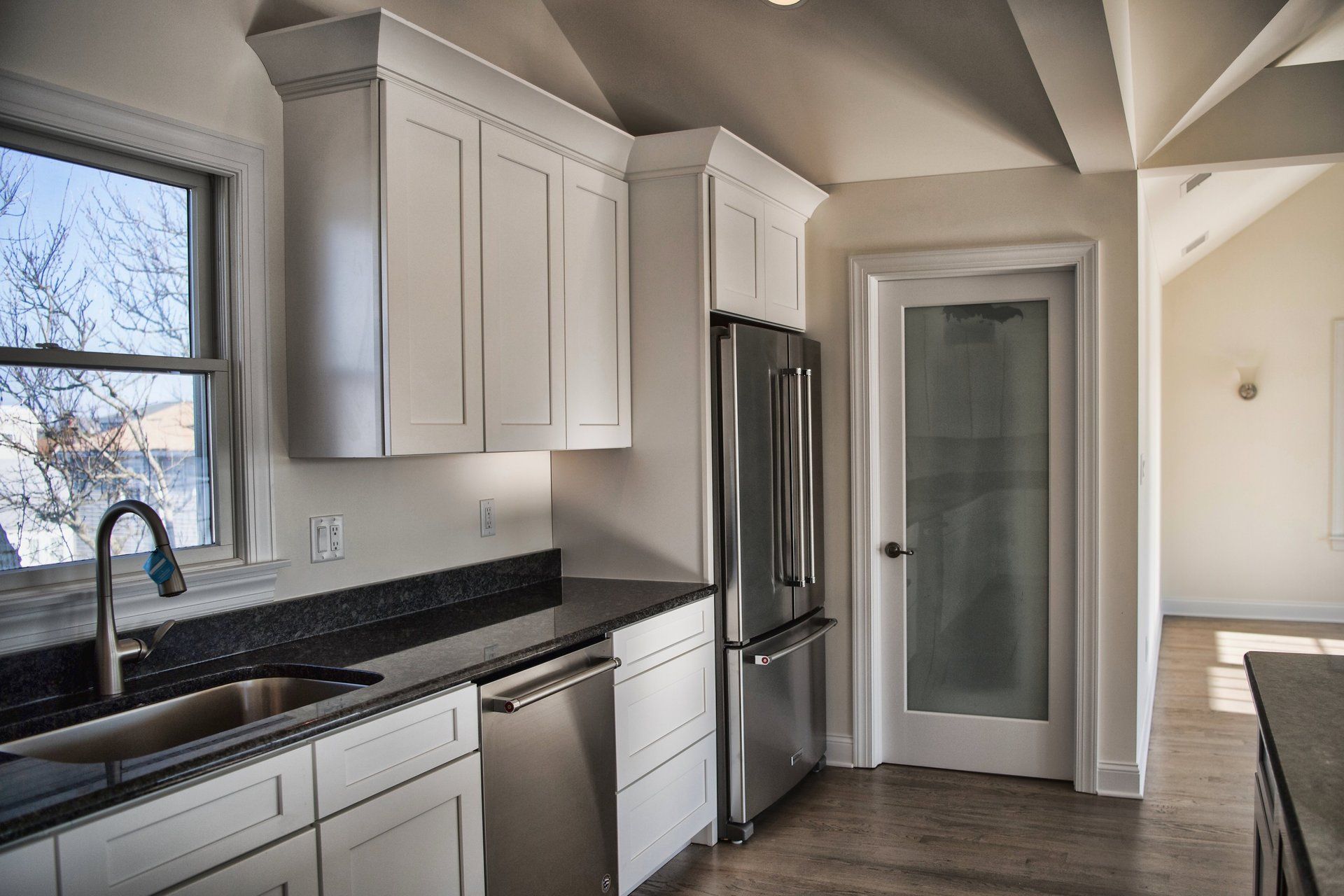 A kitchen with white cabinets and stainless steel appliances