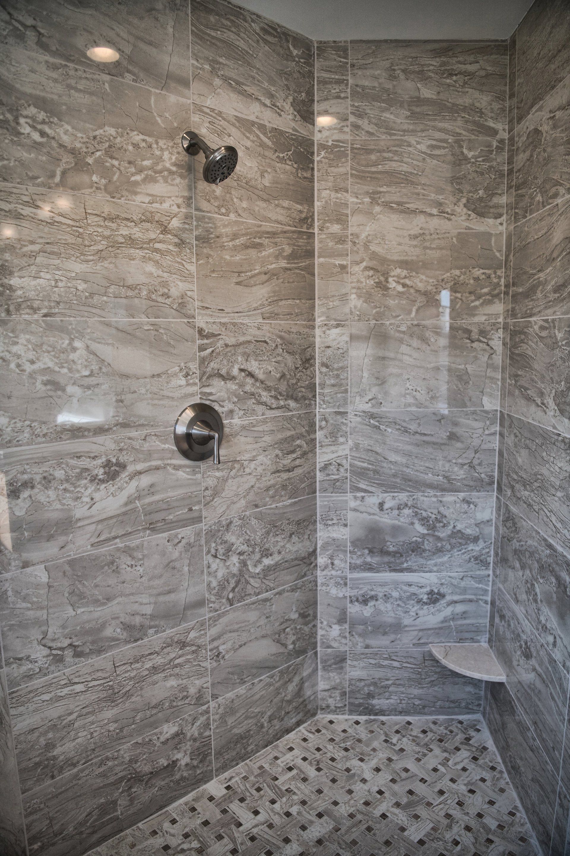 A walk in shower with a glass door and a shower head.