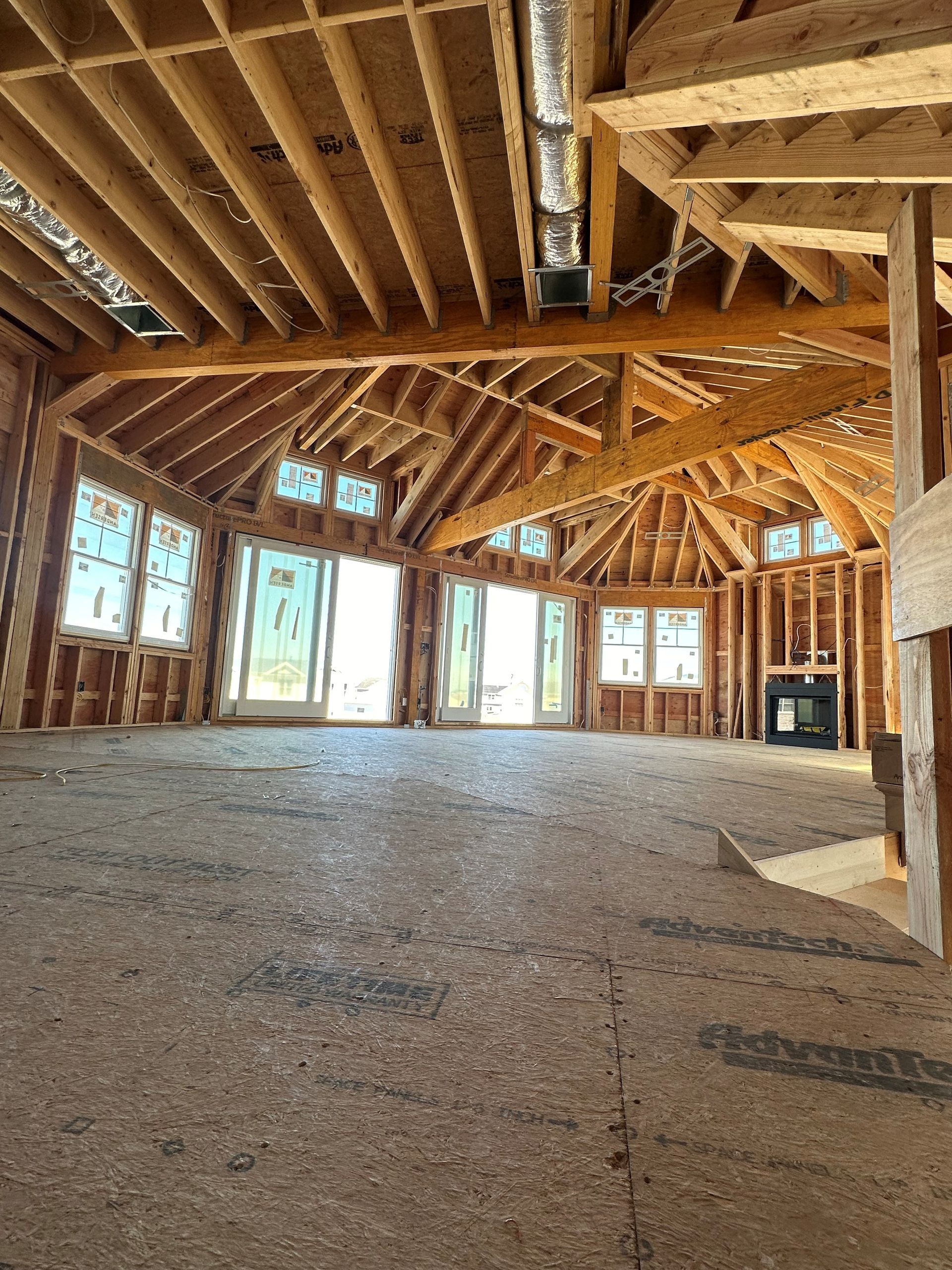 A large empty room with a lot of windows and wooden beams.