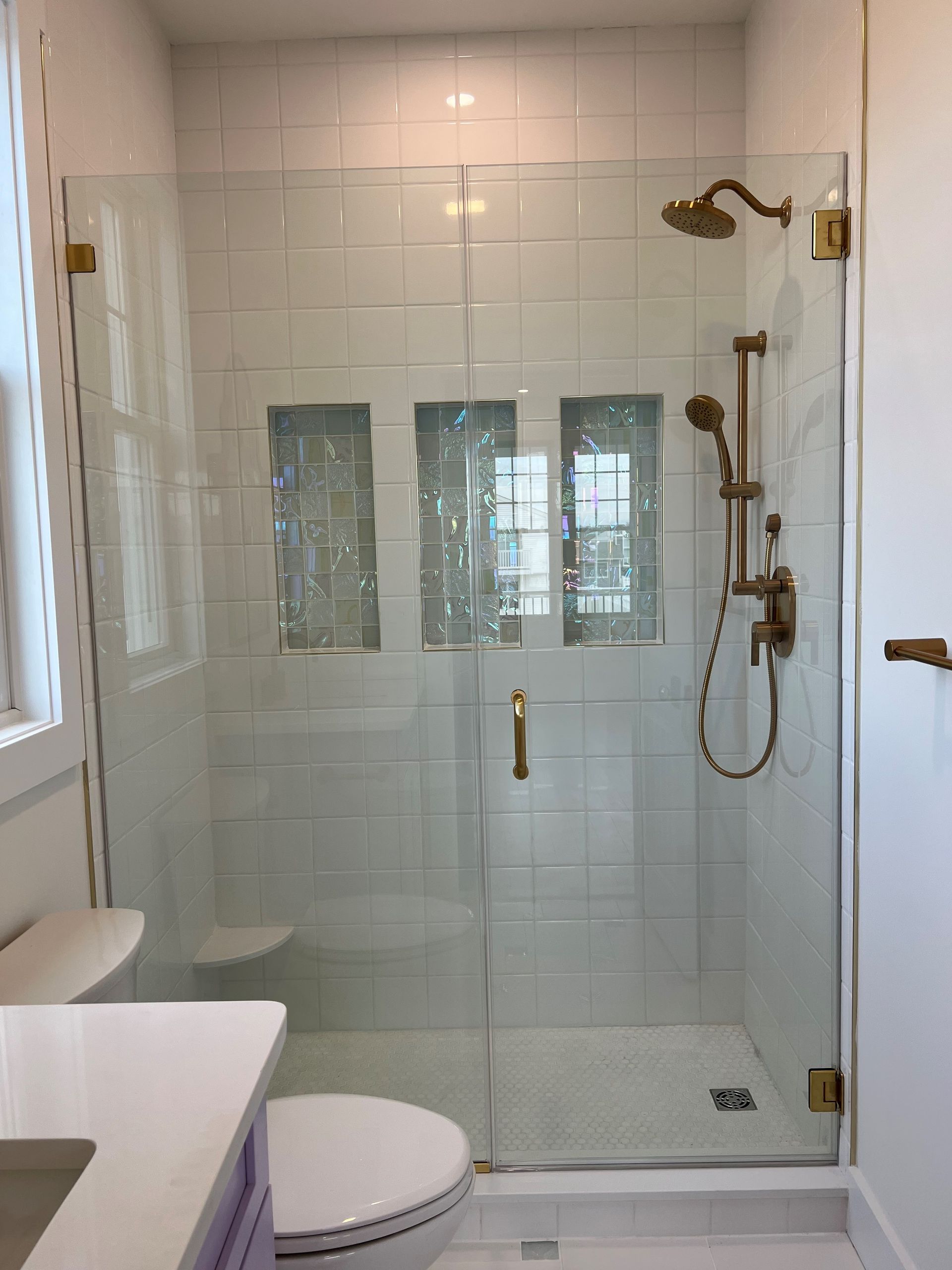 A bathroom with a toilet and a shower with a glass door