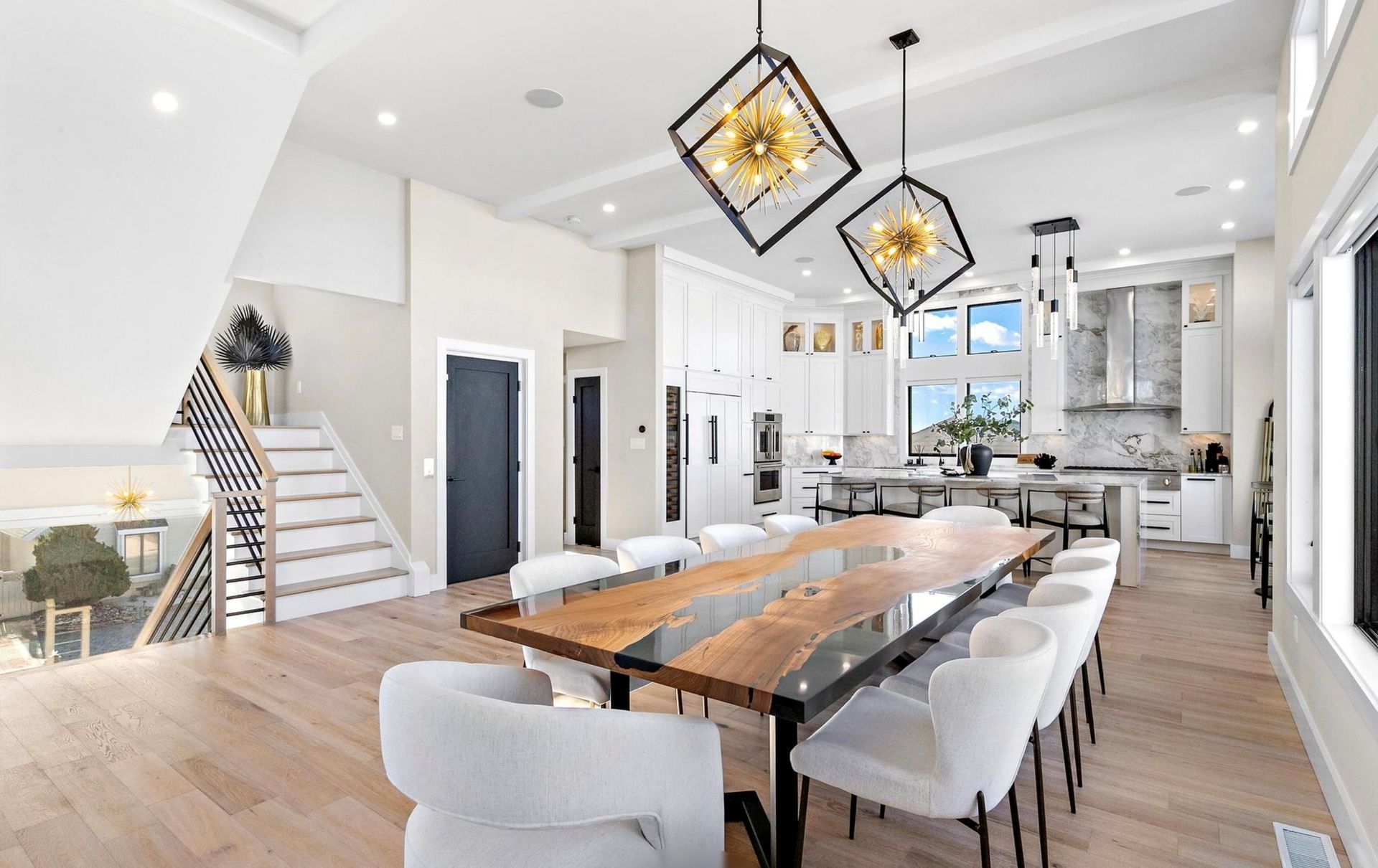 A large dining room with a wooden table and white chairs.