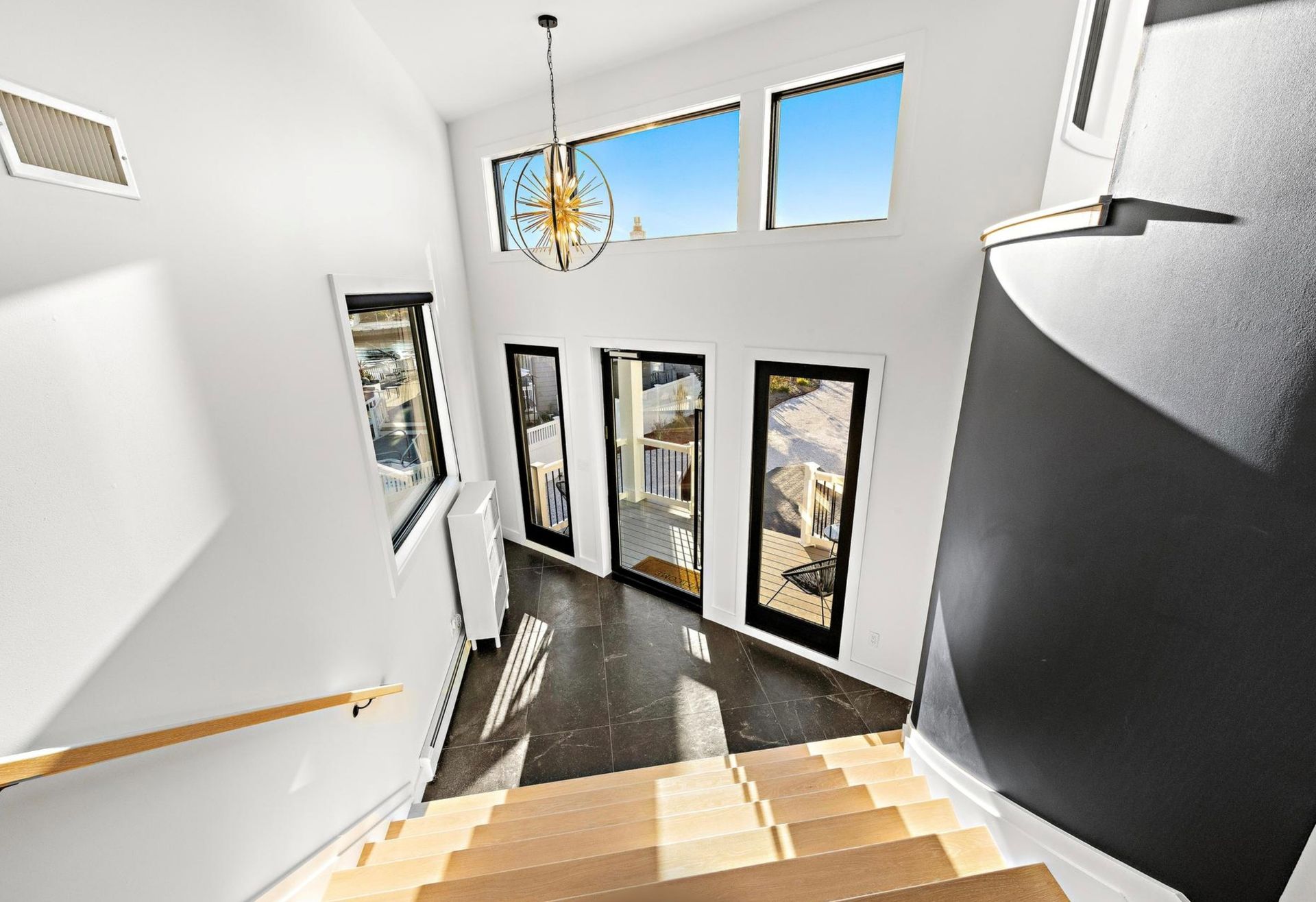 A staircase in a house with a chandelier hanging from the ceiling