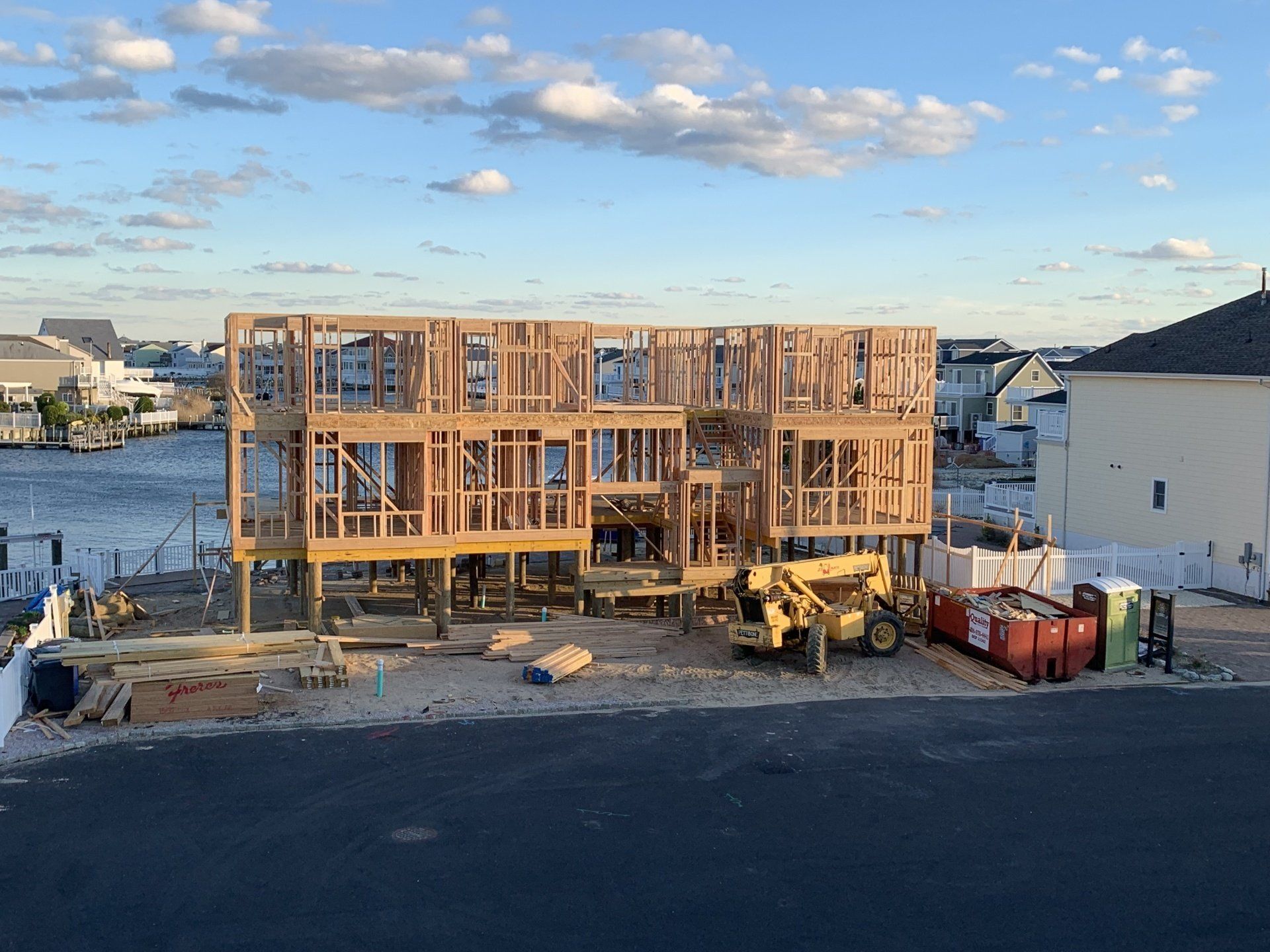 A house is being built on stilts next to a body of water.