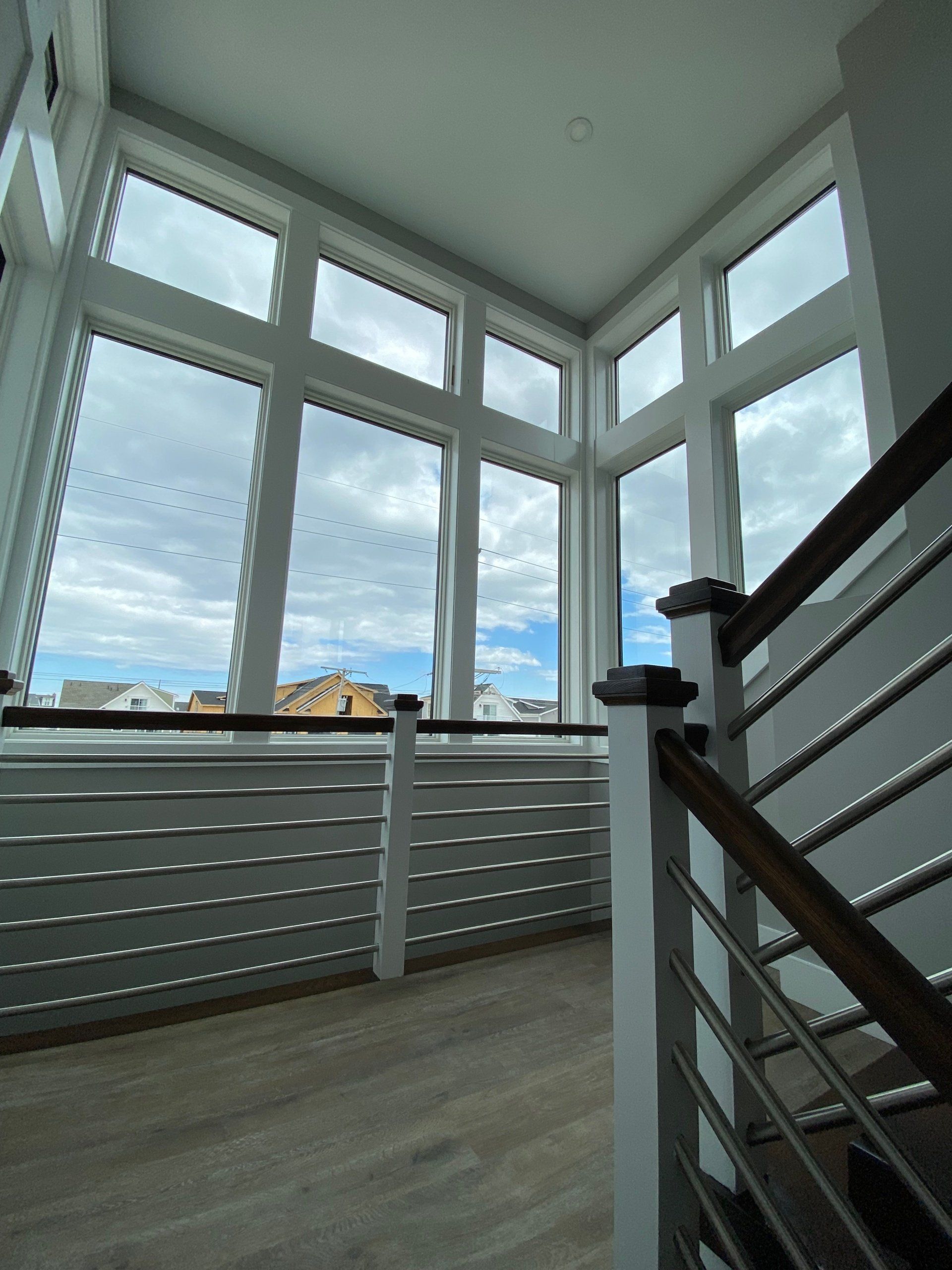 An empty room with a staircase and lots of windows
